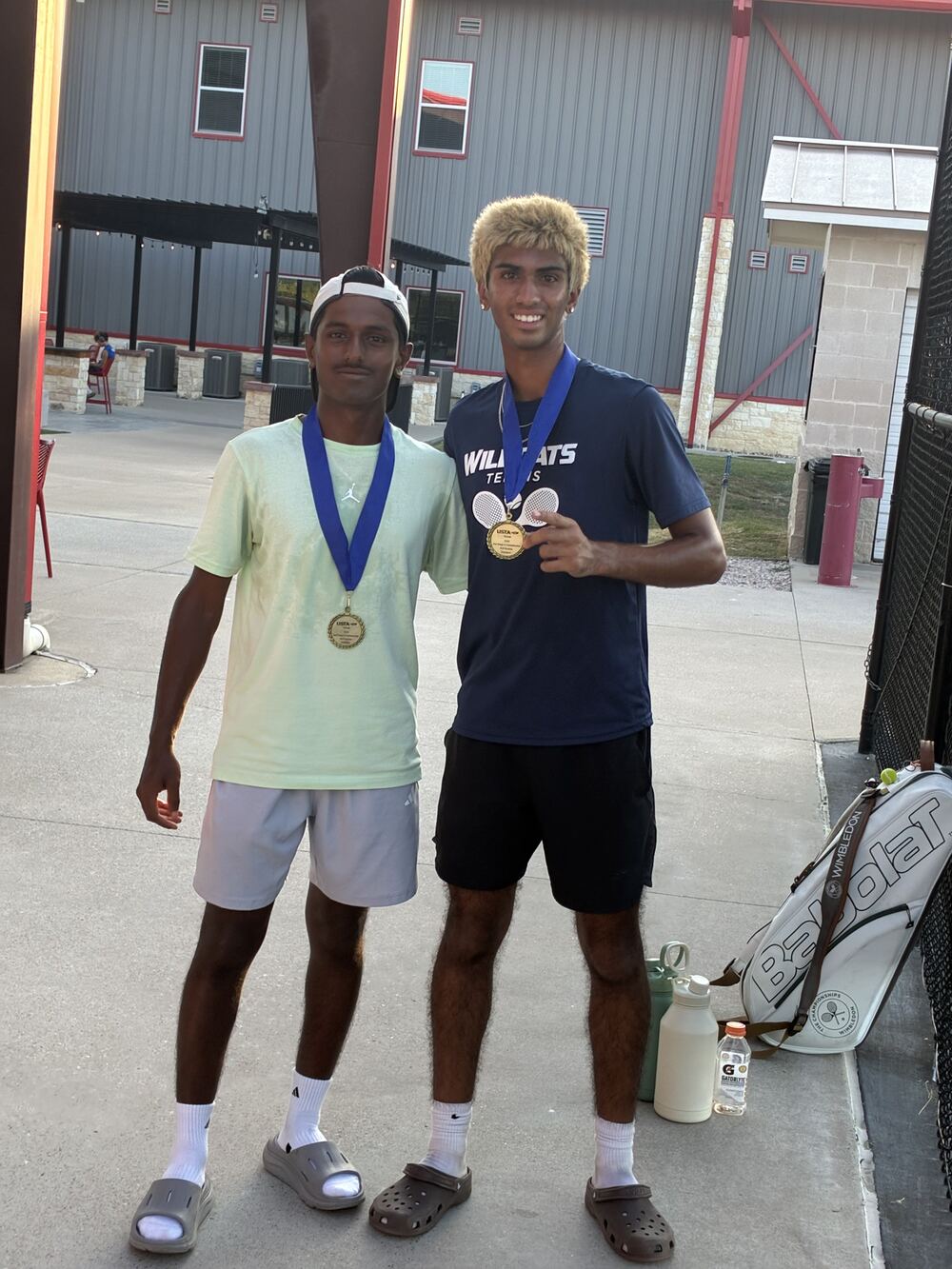 Sanjeeva and his doubles partner wearing tournament medals
