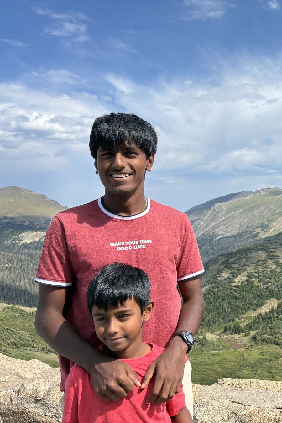 Sanjeeva smiling on a mountain overlook with his younger brother Nidhulan